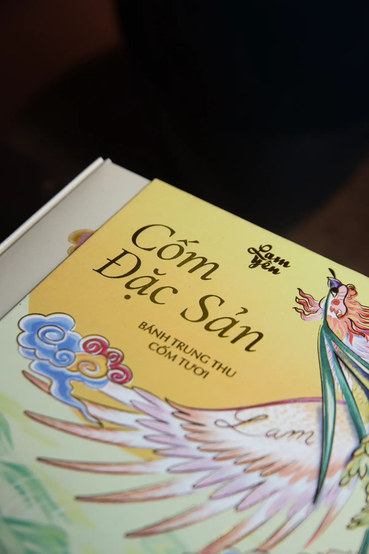 Close-up of the title “Cốm Đặc Sản” on the yellow lid of the box.